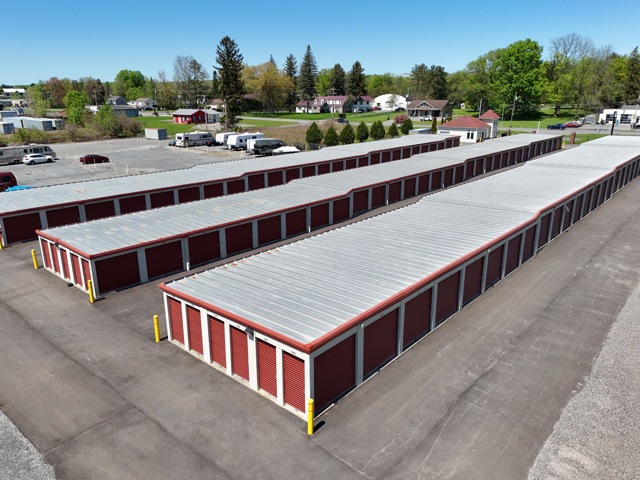 Aerial view of A-Verdi Self Storage with red storage unit doors, metal rooftops, and paved driveways.